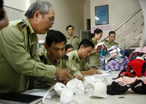 Chi cục quản lý thị trường Đà Nẵng mở niêm phong, xẻ áo ngực Trung Quốc để tìm thuốc lạ. Ảnh: Nguyễn Đông