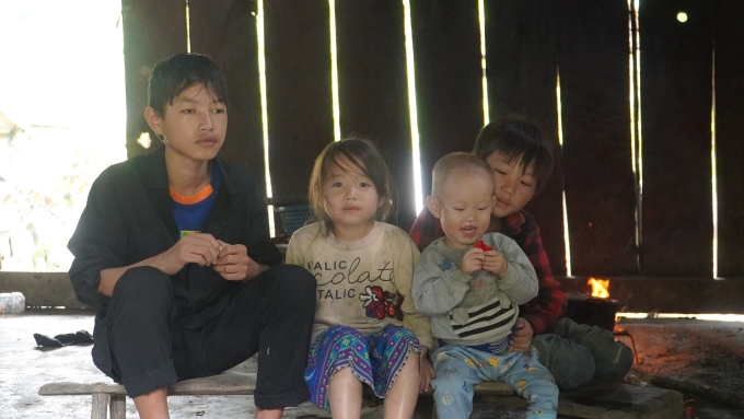 Sùng A Minh (bên trái) cùng hai em nhỏ Sùng A Thênh và Sùng Thị Dính tại ngôi nhà gỗ ở bản Huổi Khon 1 trưa ngày 21/10. Ảnh: Minh Tâm.