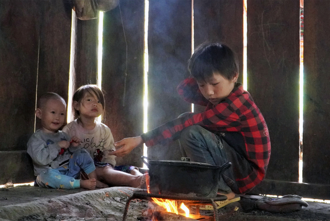 Sùng Thị Dính (áo trắng), Sùng A Thênh (áo kẻ đỏ) phụ anh trai nấu cơm, trưa 21/10. Ảnh: Minh Tâm