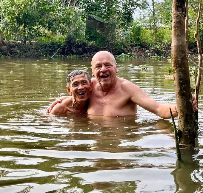 ông Jean Francois, 64 tuổi (trái), người Pháp và ông thông gia Võ Trần Tiến, 62 tuổi, người xã Hòa Long, cùng tắm sông, tháng 4/2026. Ảnh: Vy Võ