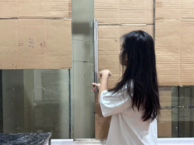 Vân Anh mở cửa ban công nơi đứa trẻ 4 tuổi bị tử vong, sáng 8/5. Theo cô, đây là nơi âm thanh có thể phát ra, khi phòng bị khóa kín. Ảnh: Phạm Nga
