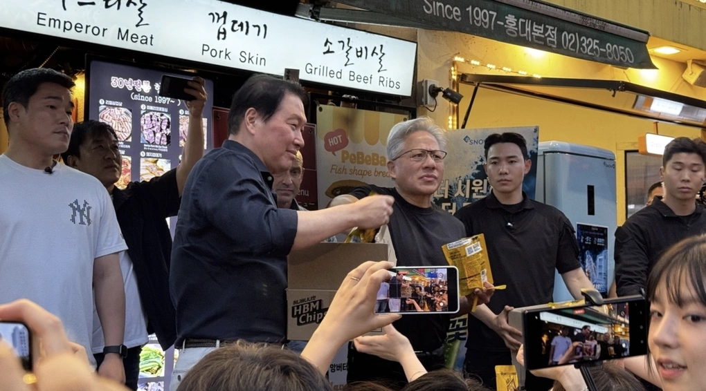 Chủ tịch SK Chey Tae-won (trái) và CEO Nvidia Jensen Huang phát đồ ăn vặt cho người dân. Ảnh: Seoul Economic Daily