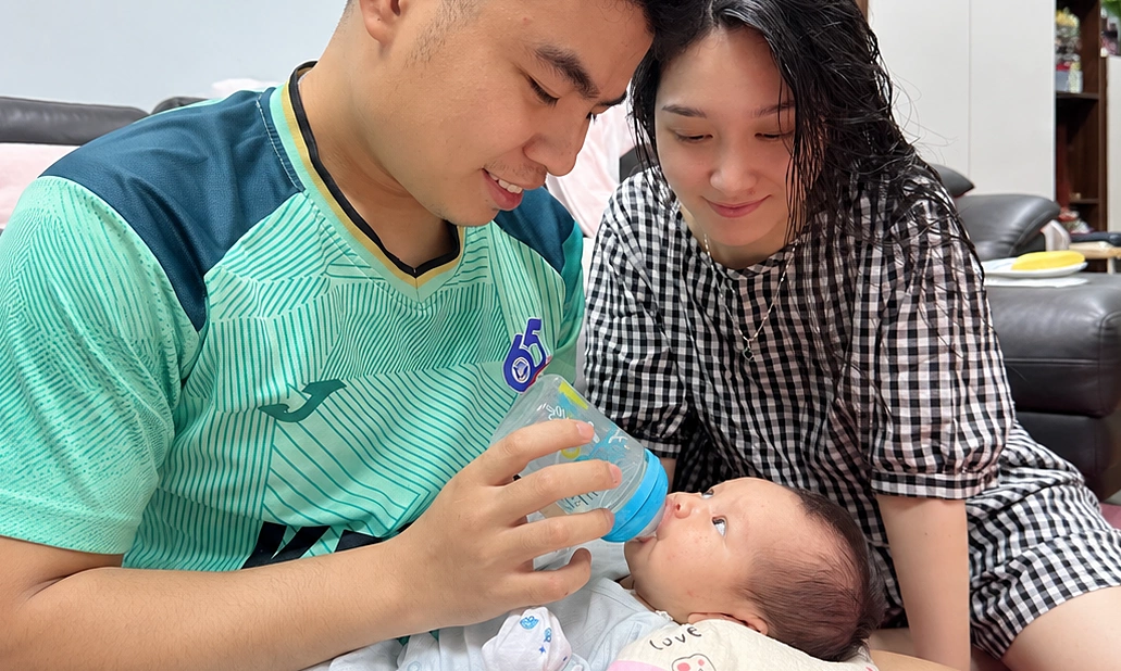 Chàng trai 24 tuổi bế em bé 6 tháng tuổi và cười tươi rạng rỡ.