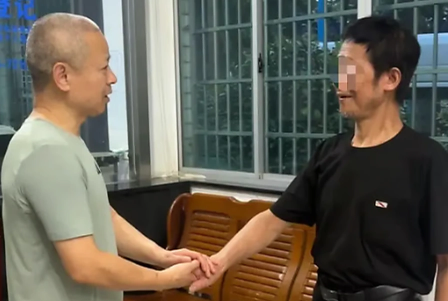 Ông Zu, bên phải, cảm ơn các nhân viên xã hội hỗ trợ mình. Ảnh: QQ.com